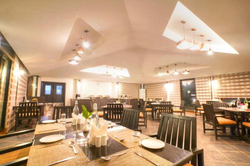 a dining room with tables and chairs in a restaurant at Bundela Bandhavgarh by Octave in Mānpur