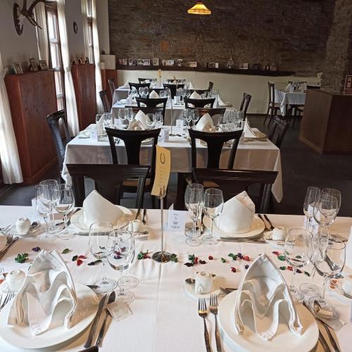 ein Esszimmer mit Tischen, weißen Tellern und Servietten in der Unterkunft Hotel Mirador de Barcia in Ribeira de Piquin