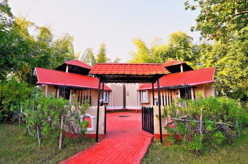a house with a red roof and a red walkway at Bundela Bandhavgarh by Octave in Mānpur