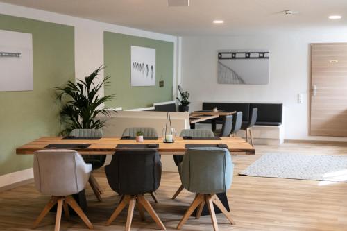 - une salle à manger avec une table et des chaises en bois dans l'établissement KRACHER Familienapartment Landhaus No 4, à Illmitz