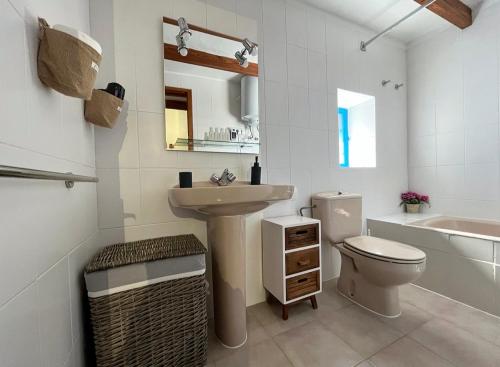 a bathroom with a sink and a toilet and a tub at Can Mateu 1924 in Sant Francesc Xavier