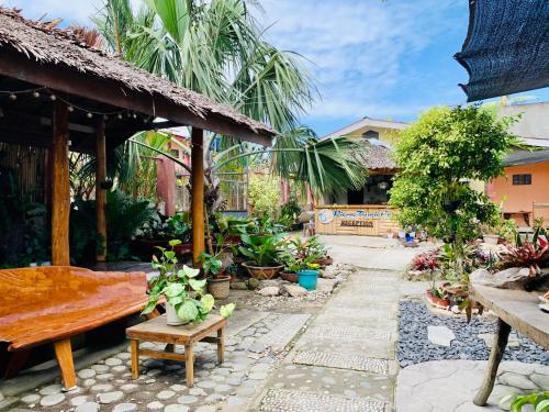 un patio con un banco y un montón de plantas en Pisces Tourist Inn - Port Barton en San Vicente