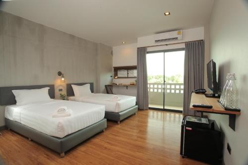 a hotel room with two beds and a television at Space59 Hotel in Ratchaburi