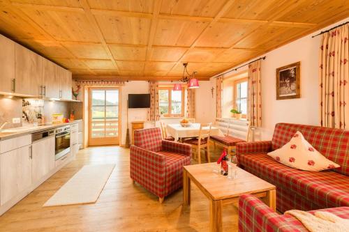 un soggiorno con divani rossi e una cucina di BioBauern- und Pferdehof Schöll a Waltenhofen