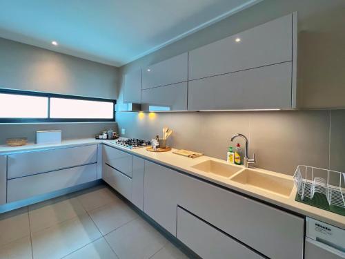 a kitchen with white cabinets and a sink at The Pier 29 in Swakopmund