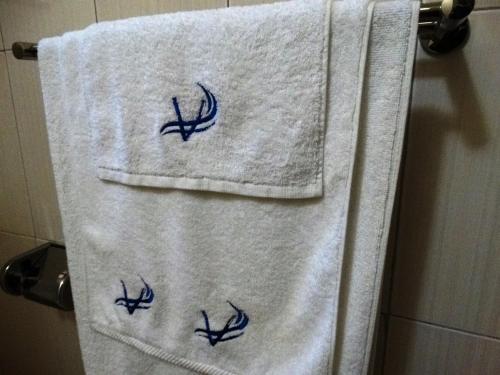 a towel hanging on a towel rack in a bathroom at Victoria Breeze Suites, Entebbe in Entebbe