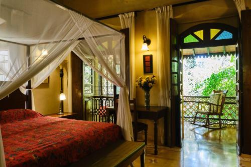 a bedroom with a bed and a window and a door at Serendipity House Goa in Nerul