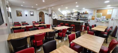 a restaurant with wooden tables and red chairs at Auberge Saint Jacques in Saint-Alban-sur-Limagnole