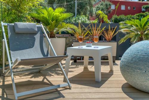 a chair and a table on a patio with plants at GROUND FLOOR VILLA GRAZIELLA 200 M FROM THE BEACH in Èze