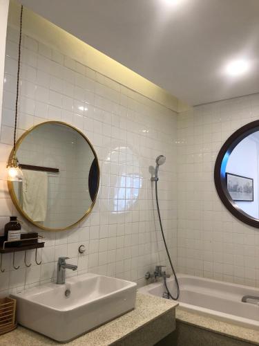 a bathroom with a sink and a mirror and a tub at OASIS - FLC SEA TOWER in Quy Nhon