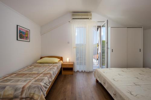 a bedroom with two beds and a window at House Goga in Ledenice