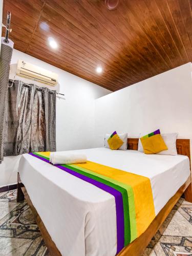 a bedroom with a bed with a rainbow blanket at Hotel OakWood Baga in Baga