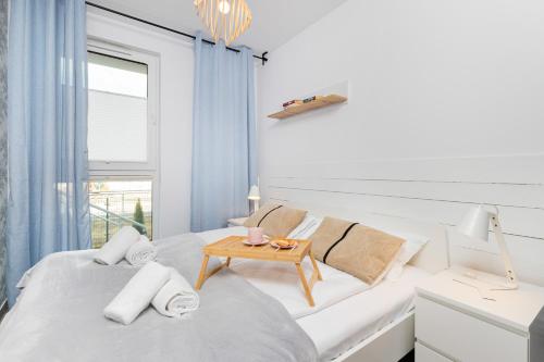 a white bedroom with a white couch and a table at Apartment Gdańsk Downtown by Renters in Gdańsk