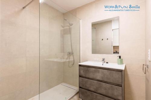 ein Bad mit einer Dusche, einem Waschbecken und einem Spiegel in der Unterkunft Apartamento Martin Villa in Sevilla