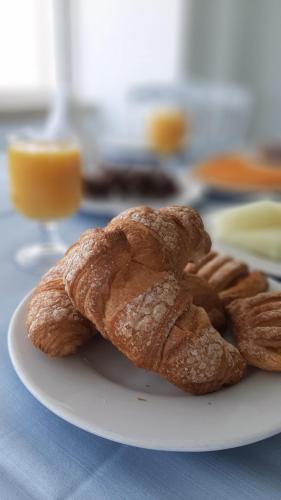 a white plate with a croissant and pretzels on a table at Hotel Albatros in Ischia