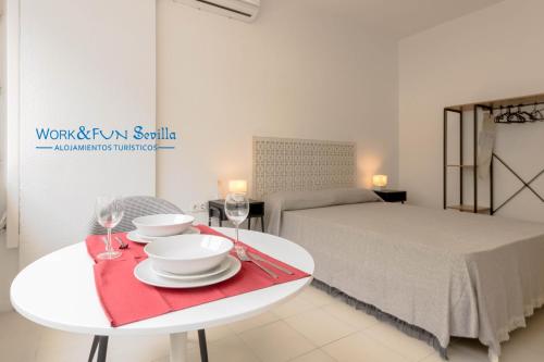 Zimmer mit einem Bett und einem Tisch mit Weingläsern in der Unterkunft Apartamento Martin Villa in Sevilla