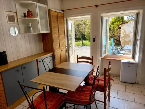 a table and chairs in a kitchen with a view of a patio at GITE ENTRE TERRE ET MER GRAND STUDIO in Mareuil-sur-Lay