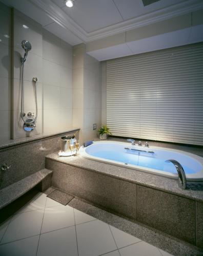 a large bathroom with a tub with a window at Hotel La Suite Kobe Harborland in Kobe