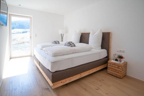 a bedroom with a bed with white sheets and a window at My Mountain Destination in Sautens