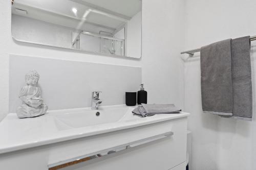 a white bathroom with a sink and a mirror at Second Home - Ferienwohnungen Fischbach in Friedrichshafen