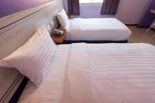 Postel nebo postele na pokoji v ubytování Thungtawan Hotel