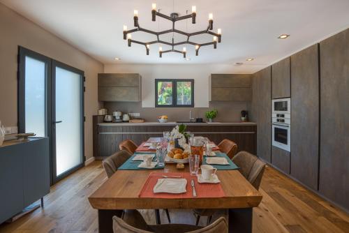 a kitchen and dining room with a table and a chandelier at GROUND FLOOR VILLA GRAZIELLA 200 M FROM THE BEACH in Èze