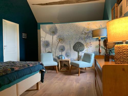 um quarto com uma cama, 2 cadeiras e uma parede em L’En Vert du Monde em Saint-Boil