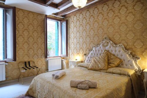 sypialnia z dużym łóżkiem w pokoju z tapetą w obiekcie La Residenza di Carlo close to Piazza San marco w Wenecji