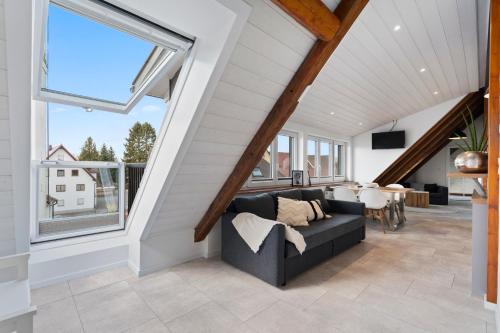 a living room with a couch and a large window at Second Home - Ferienwohnungen Fischbach in Friedrichshafen