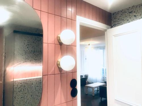 baño con una pared de azulejos rosas con luces en Nid Douillet 2 - Appartement cosy avec garage, en Grenoble