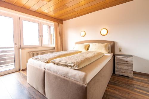 - une chambre avec un grand lit et un plafond en bois dans l'établissement Steinbühler Hof - Stressfrei am Lande, à Bad Kötzting