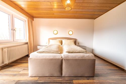 - une chambre avec un lit et un plafond en bois dans l'établissement Steinbühler Hof - Stressfrei am Lande, à Bad Kötzting