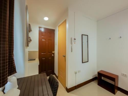 een kleine kamer met een deur en een spiegel bij Super OYO 856 City Stay Inns Slex Makati in Manilla