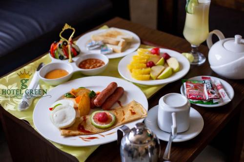 Hotel Green في Spintex: طاولة عليها أطباق من طعام الإفطار