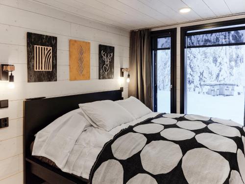 a bedroom with a black and white bed and a window at Villa Aikku in Syöte