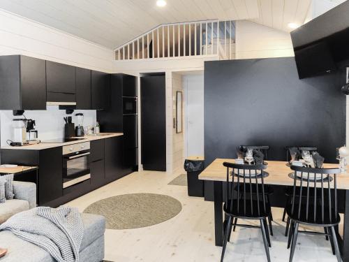 a kitchen and living room with black cabinets and a table at Villa Aikku in Syöte