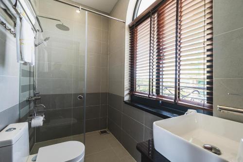 a bathroom with a toilet and a sink at City Center Rosa Hotel in Phu Quoc