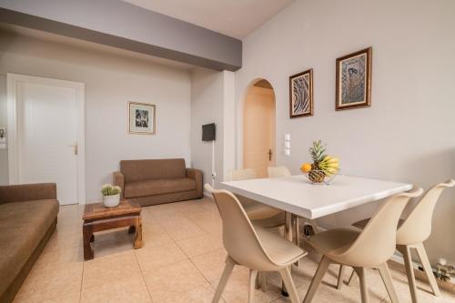 a living room with a white table and chairs at Armonia Boutique Hotel in Meson Yerakarion