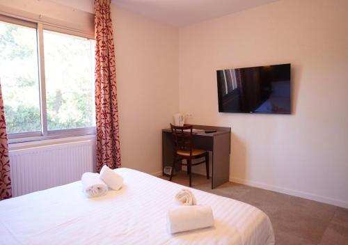 a bedroom with a bed and a desk and a television at Hotel et Studios Le Marina Baie de La Baule in Pornichet