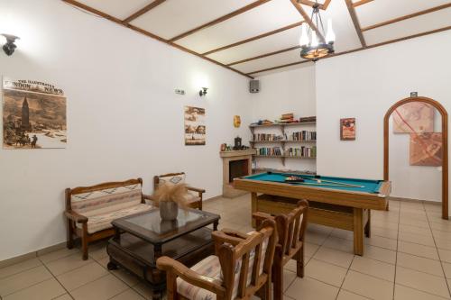 a living room with a pool table and chairs at Armonia Boutique Hotel in Meson Yerakarion
