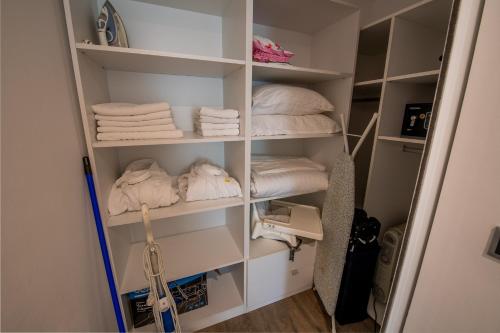 una habitación con estanterías blancas con toallas. en SuperApartment, en Poiana Brasov