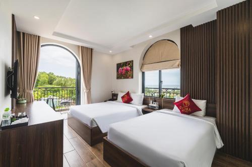 a hotel room with two beds and a balcony at City Center Rosa Hotel in Phu Quoc