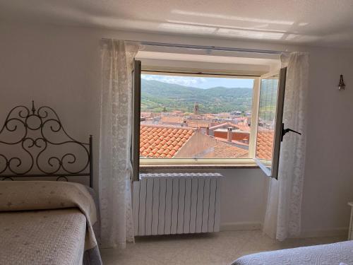 a bedroom with a window with a view at A Casa di Anna in Mamoiada