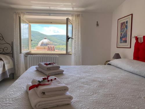 a bedroom with towels on a bed with a window at A Casa di Anna in Mamoiada