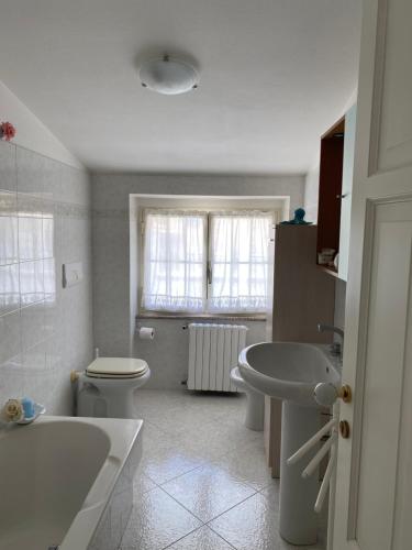 a bathroom with a tub and a toilet and a sink at A Casa di Anna in Mamoiada