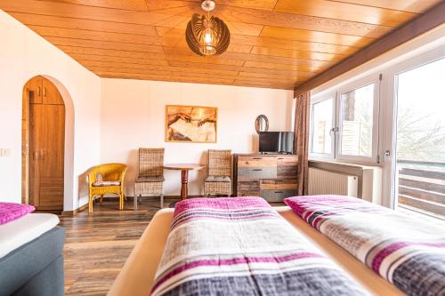 a bedroom with a bed and a table with chairs at Steinbühler Hof - Stressfrei am Lande in Bad Koetzting