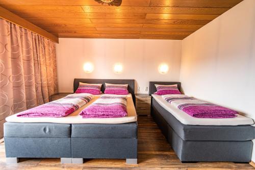 two beds in a room with purple pillows at Steinbühler Hof - Stressfrei am Lande in Bad Koetzting