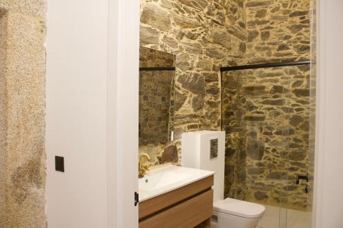 baño con pared de piedra en O lar de San Fins-Casita rural, en A Coruña