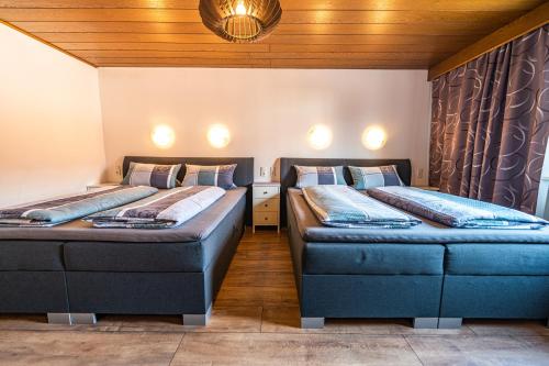 two beds in a room with wooden ceilings at Steinbühler Hof - Stressfrei am Lande in Bad Koetzting