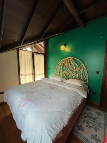 a bedroom with a large bed with a green wall at Villa Özdilek in Sapanca